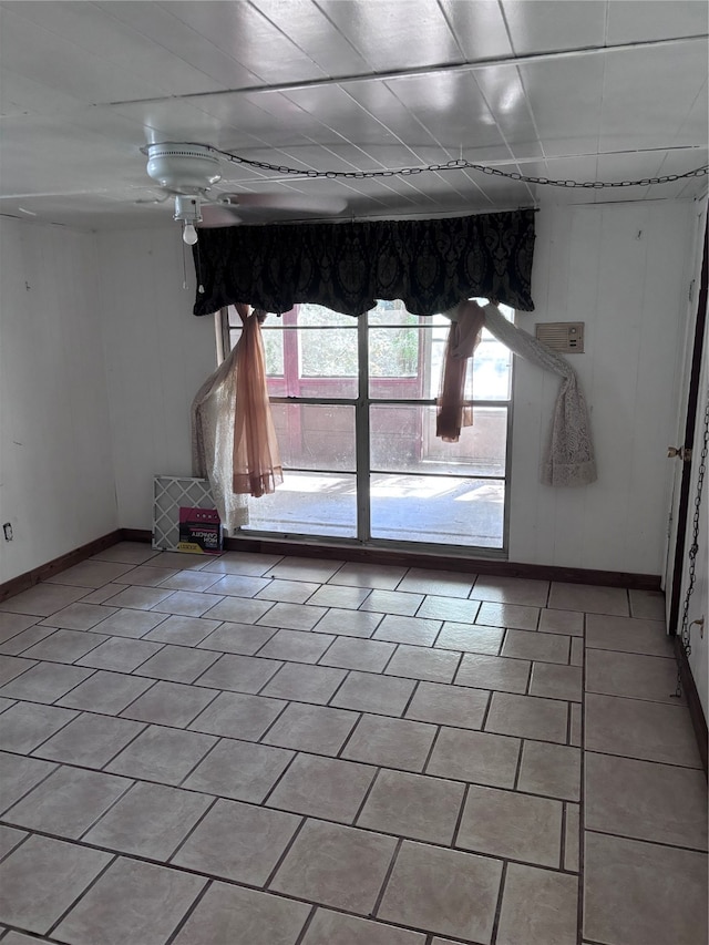 empty room with light tile patterned flooring and a paneled ceiling