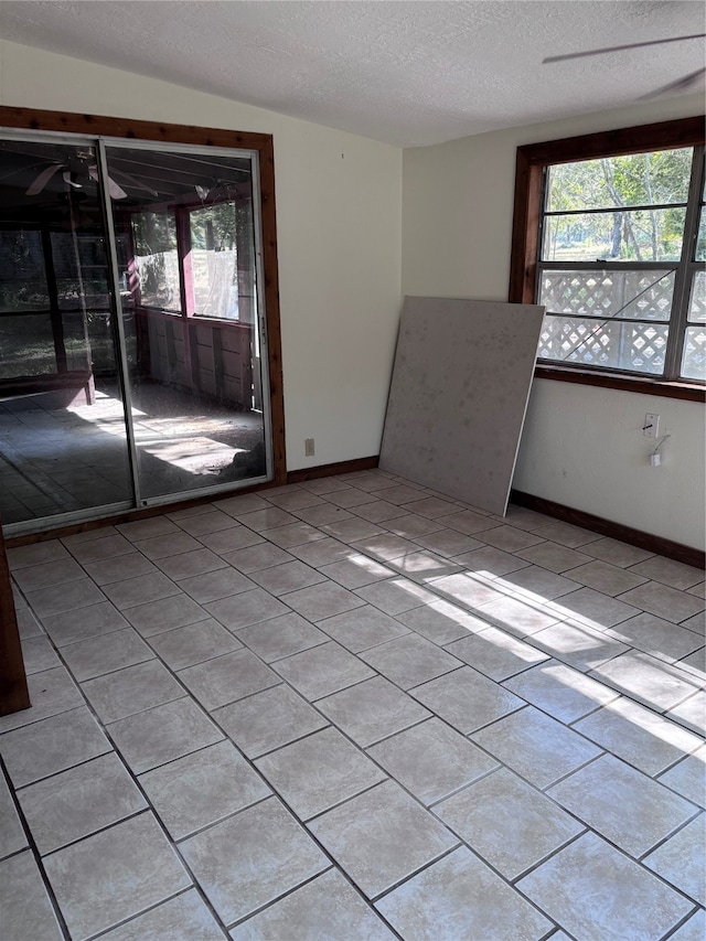 empty room with light tile patterned floors and a textured ceiling