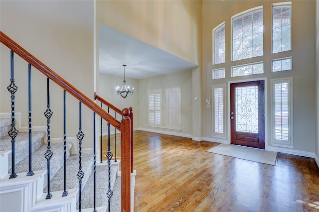 entryway featuring hardwood / wood-style flooring, a high ceiling, and a chandelier