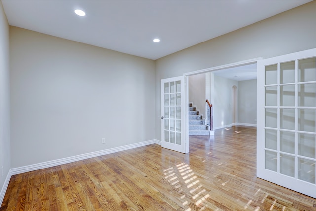 spare room with light hardwood / wood-style floors and french doors