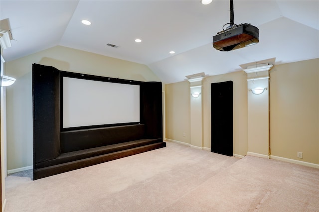 carpeted home theater featuring lofted ceiling