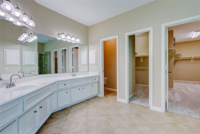 bathroom with tile patterned flooring, vanity, and a shower with door