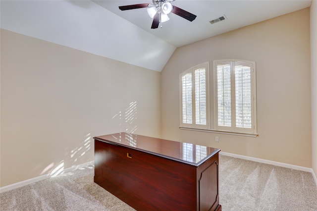 unfurnished office with light carpet, ceiling fan, and vaulted ceiling