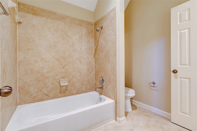 bathroom with toilet, tiled shower / bath combo, and tile patterned floors