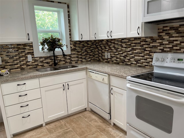 kitchen featuring white appliances, white cabinets, and sink