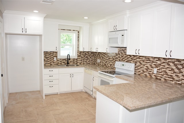 kitchen with white appliances, sink, kitchen peninsula, backsplash, and white cabinetry