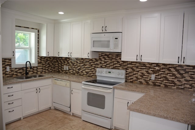 kitchen featuring white appliances, sink, light stone counters, backsplash, and white cabinetry