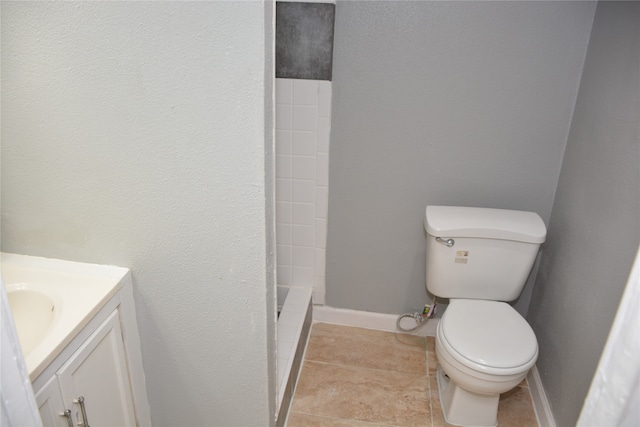 bathroom featuring tile patterned flooring, walk in shower, vanity, and toilet