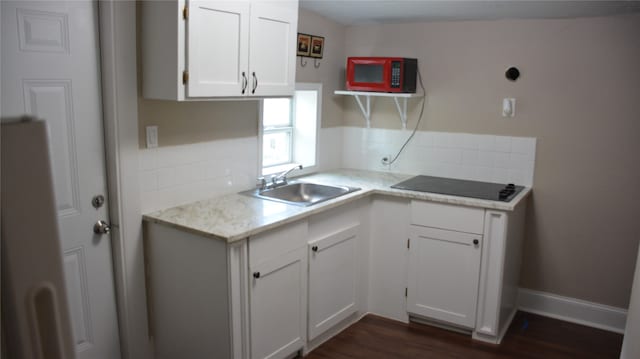 kitchen featuring dark hardwood / wood-style flooring, sink, decorative backsplash, white cabinets, and black appliances