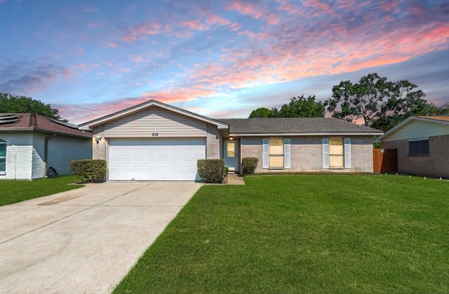 single story home featuring a garage and a lawn