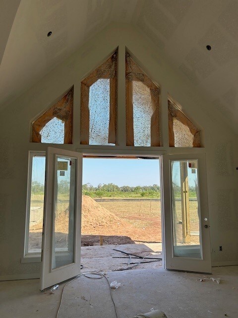 doorway featuring a rural view and vaulted ceiling