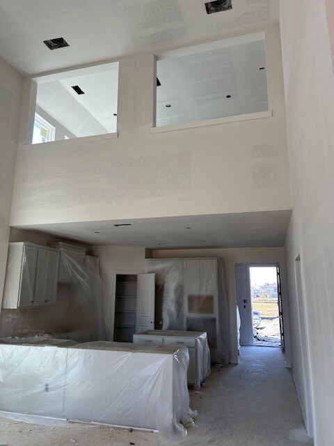 unfurnished bedroom featuring high vaulted ceiling