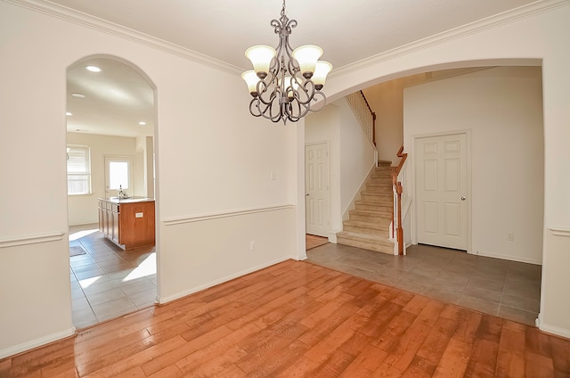 unfurnished room with ornamental molding, sink, and light wood-type flooring