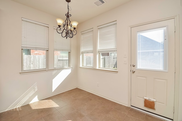 interior space with a notable chandelier, plenty of natural light, and light tile patterned floors