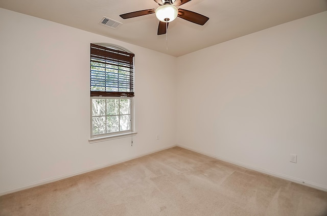 spare room featuring light carpet and ceiling fan