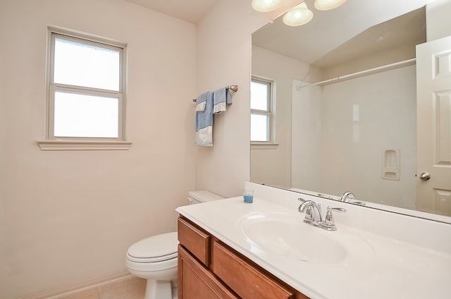 bathroom with vanity, plenty of natural light, toilet, and tile patterned flooring