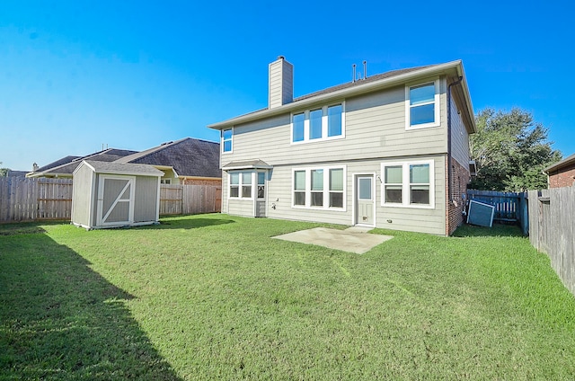 rear view of house featuring a storage shed and a yard