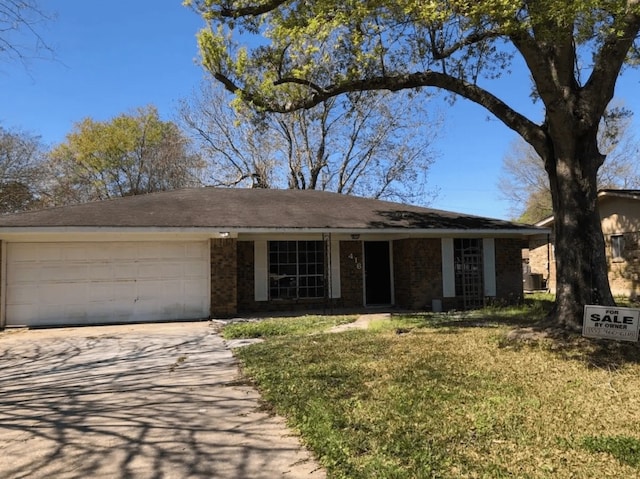 ranch-style house featuring a garage and a front lawn