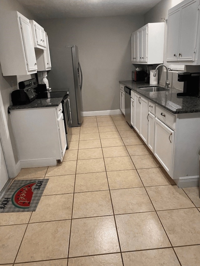 kitchen featuring light tile patterned floors, appliances with stainless steel finishes, sink, and white cabinetry