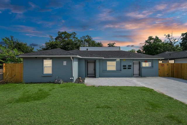 back house at dusk with a lawn