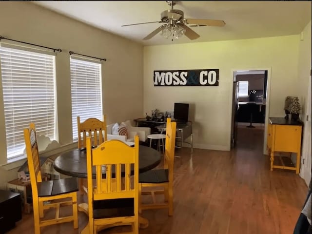 dining room featuring dark wood-type flooring, ceiling fan, and a healthy amount of sunlight