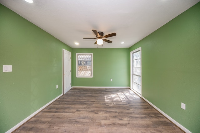 spare room featuring a wealth of natural light, hardwood / wood-style floors, and ceiling fan