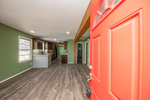 kitchen featuring dark hardwood / wood-style flooring, beamed ceiling, and sink