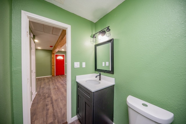 bathroom featuring vanity, wood-type flooring, and toilet