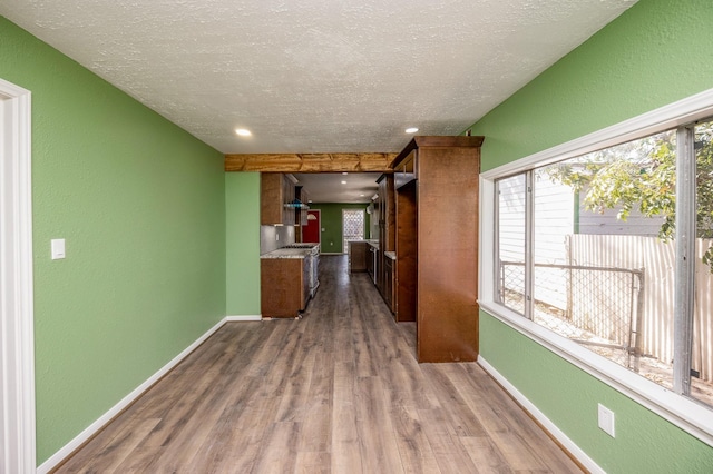 hallway featuring a textured ceiling and light hardwood / wood-style floors