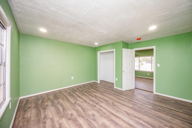 unfurnished bedroom with a textured ceiling and hardwood / wood-style flooring