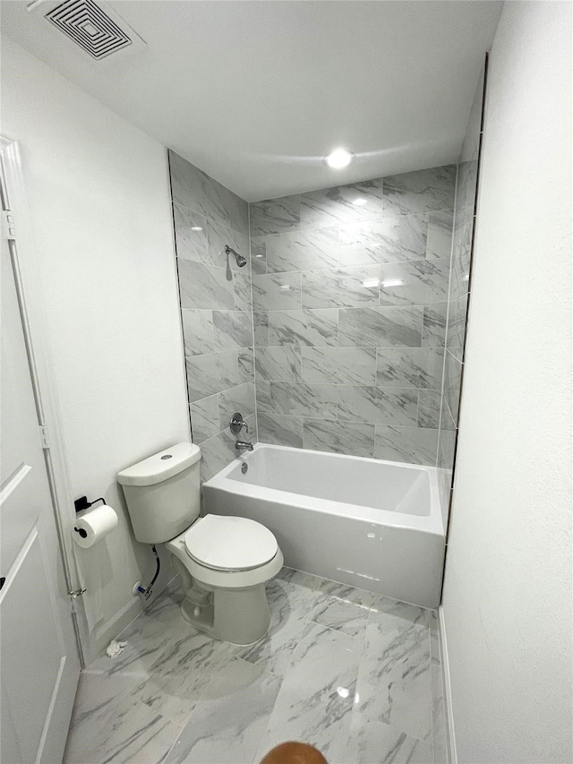 bathroom with toilet and tiled shower / bath combo