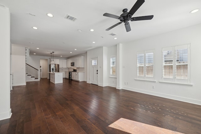 unfurnished living room with ceiling fan and dark hardwood / wood-style floors