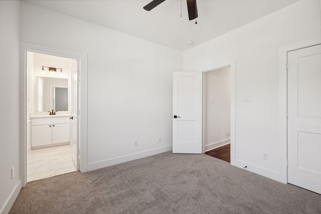 unfurnished bedroom with sink, dark colored carpet, connected bathroom, and ceiling fan