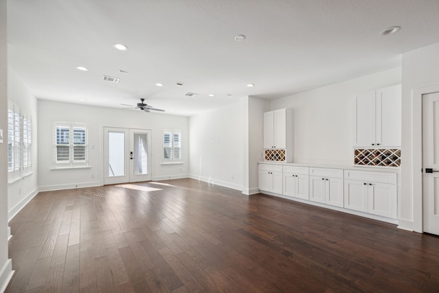 unfurnished room featuring ceiling fan, a wealth of natural light, french doors, and dark hardwood / wood-style floors