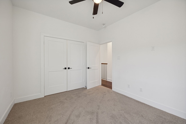 unfurnished bedroom featuring carpet floors, a closet, and ceiling fan