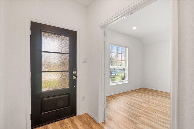 foyer entrance featuring lofted ceiling and light hardwood / wood-style floors