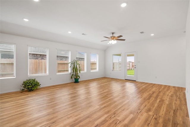 empty room with ceiling fan, light hardwood / wood-style flooring, and vaulted ceiling