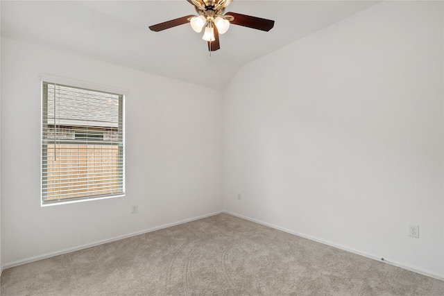 spare room with lofted ceiling, ceiling fan, and light carpet