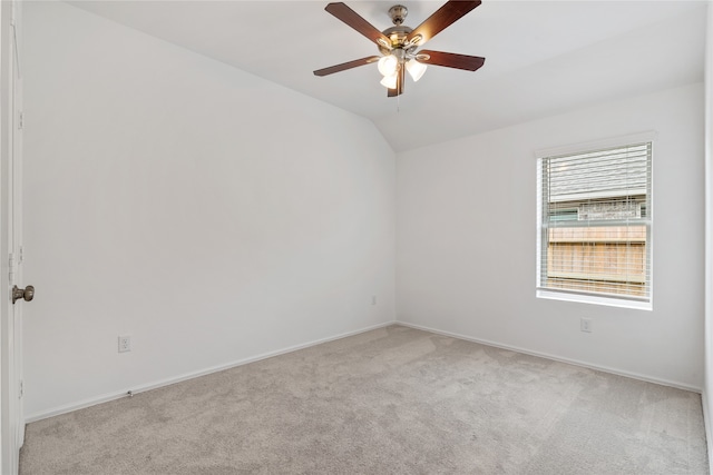 carpeted spare room featuring ceiling fan and vaulted ceiling