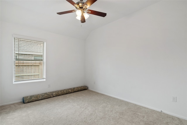 empty room featuring lofted ceiling, carpet, and ceiling fan