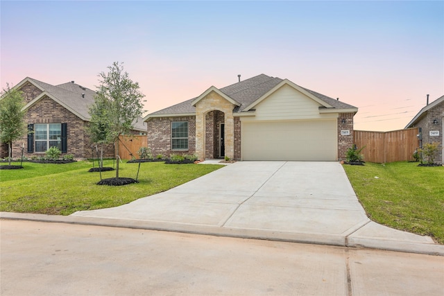 ranch-style home featuring driveway, an attached garage, fence, a front lawn, and brick siding