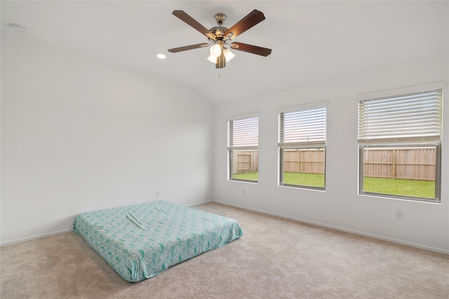 bedroom featuring lofted ceiling, light carpet, and ceiling fan