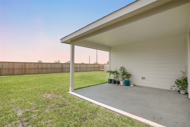 yard at dusk featuring a patio area