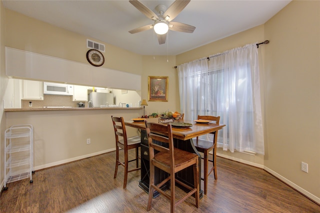 dining space with ceiling fan and dark hardwood / wood-style flooring