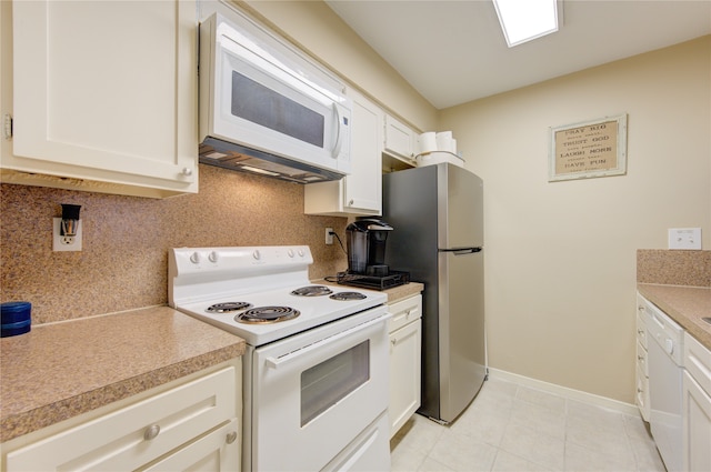 kitchen featuring decorative backsplash, light tile patterned floors, white cabinets, and white appliances