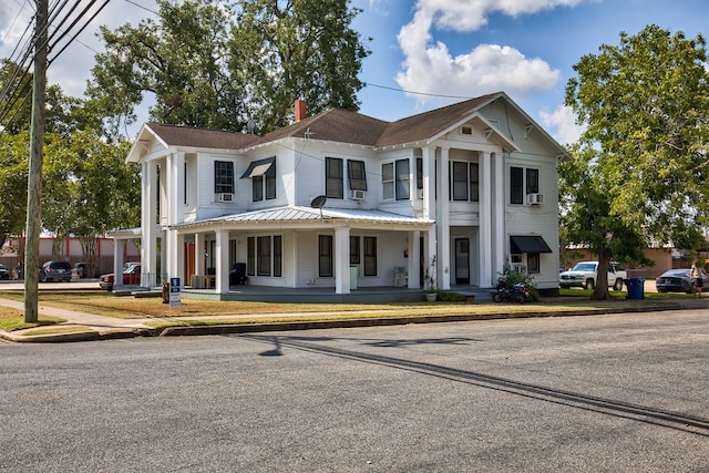 neoclassical home featuring a porch and cooling unit