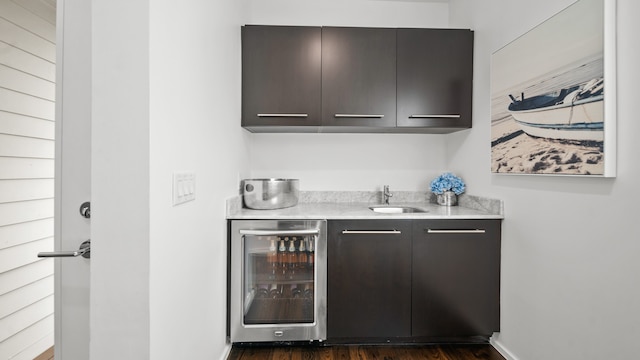 bar with dark hardwood / wood-style floors, sink, and beverage cooler