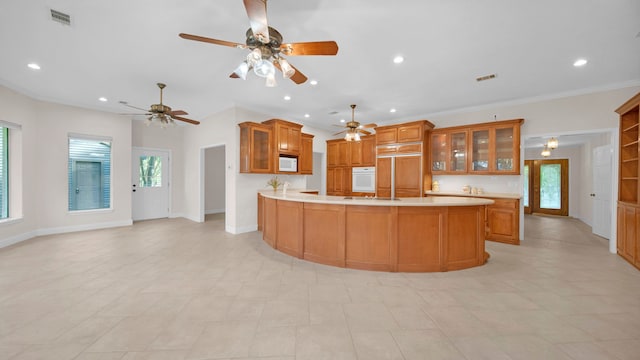 kitchen featuring light tile patterned floors, crown molding, kitchen peninsula, and white appliances