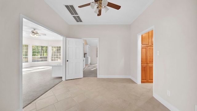 empty room with ceiling fan, crown molding, and light carpet