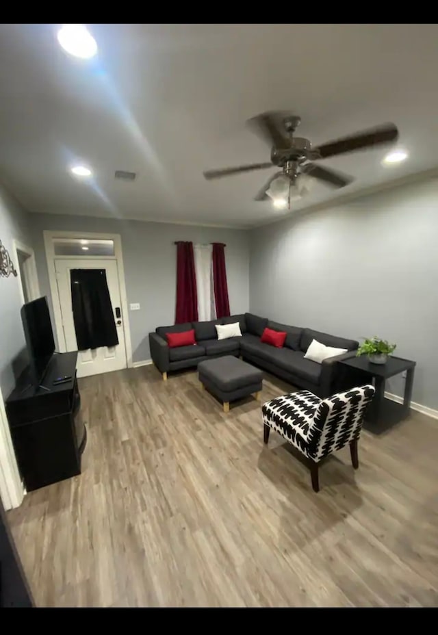 living room with ceiling fan and light hardwood / wood-style flooring